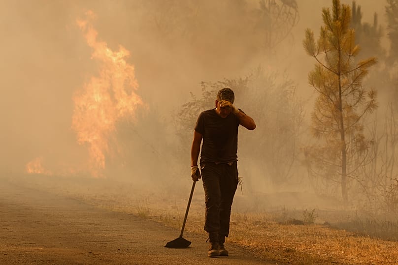 Un voluntario reacciona frente a un incendio forestal en Larouco, noroeste de España, el miércoles 13 de agosto de 2025. (AP Photo/Lalo R. Villar)