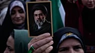امرأة ترفع صورة المرشد الأعلى الإيراني آية الله مجتبى خامنئي خلال مسيرة نظمتها الدولة احتفالاً بذكرى ميلاد الإمام الرضا، الإمام الثامن للشيعة، وإظهاراً لدعمهم للمرشد الأعلى، ف
