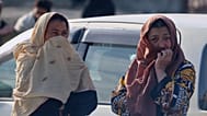 امرأتان تراقبان عمال الإنقاذ والمسؤولين وهم يتفقدون موقع غارة جوية وقعت في وقت متأخر من مساء الاثنين على مستشفى لإعادة تأهيل مدمني المخدرات في كابول، أفغانستان، الثلاثاء 17 ما