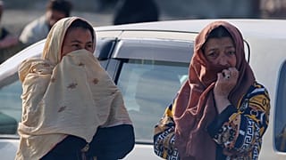 امرأتان تراقبان عمال الإنقاذ والمسؤولين وهم يتفقدون موقع غارة جوية وقعت في وقت متأخر من مساء الاثنين على مستشفى لإعادة تأهيل مدمني المخدرات في كابول، أفغانستان، الثلاثاء 17 ما