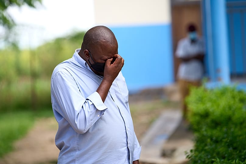 A man reacts at the site of a fire in the Ebola treatment center of Rwampara, Congo, Thursday, May 21, 2026.