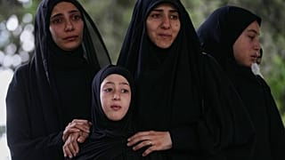 يشارك مشيّعون في مراسم تشييع أشخاص قُتلوا الثلاثاء جراء غارات جوية إسرائيلية استهدفت بلدة دير قانون النهر في جنوب لبنان، الخميس 21 مايو/أيار 2026.
