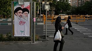 نساء يمررن أمام لافتة تظهر صور المرشد الأعلى الإيراني آية الله مجتبى خامنئي، على اليسار، ووالده المرشد الأعلى المقتول آية الله علي خامنئي في طهران، إيران، الثلاثاء 12 مايو 202