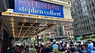 Fans line up in the rain outside the Ed Sullivan Theater in New York on Thursday, May 21, 2026, ahead of the final episode of "The Late Show with Stephen Colbert