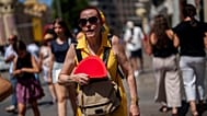 Uma mulher abana-se para se refrescar em Madrid, Espanha, 10 de julho de 2023.