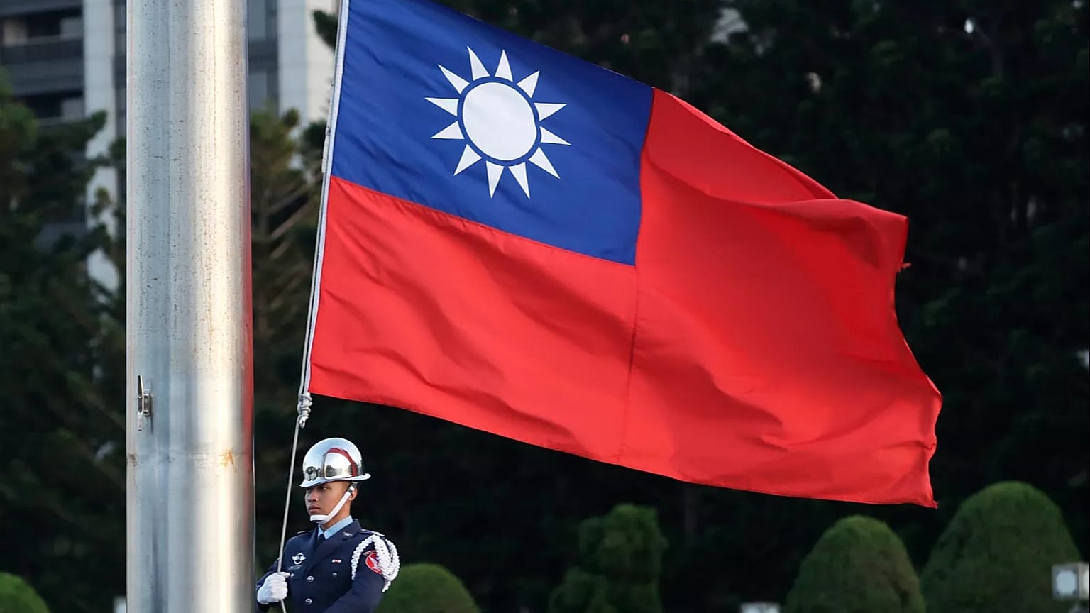 A soldier lowers the Taiwan national flag during the daily flag ceremony at the Chiang Kai-shek Memorial Hall in Taipei, 29 April, 2025