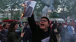 İstanbul'da Özgür Özel'e destek yürüyüşü yapan insanlar arasında bir kişi, CHP eski lideri Kemal Kılıçdaroğlu'nun fotoğrafını yakarken. / 22 Mayıs 2026 Cuma