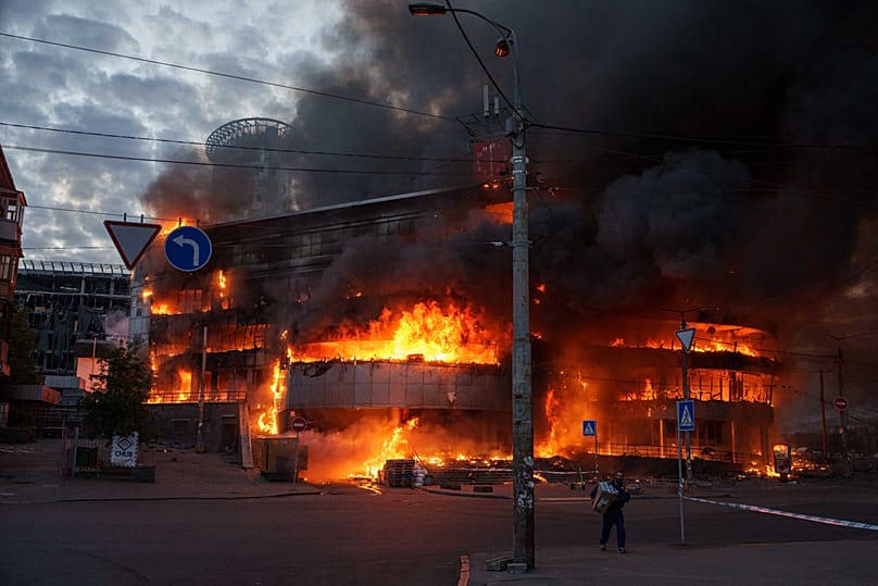 A man carries a box from a burning trade center after a Russian strike on Kyiv, Ukraine, on Sunday, May 24, 2026. 
