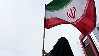 امرأة تحمل العلم الإيراني في حملة مؤيدة للحكومة في وسط مدينة طهران، إيران، السبت 25 أبريل 2026. (AP Photo/فاهد سليمي)