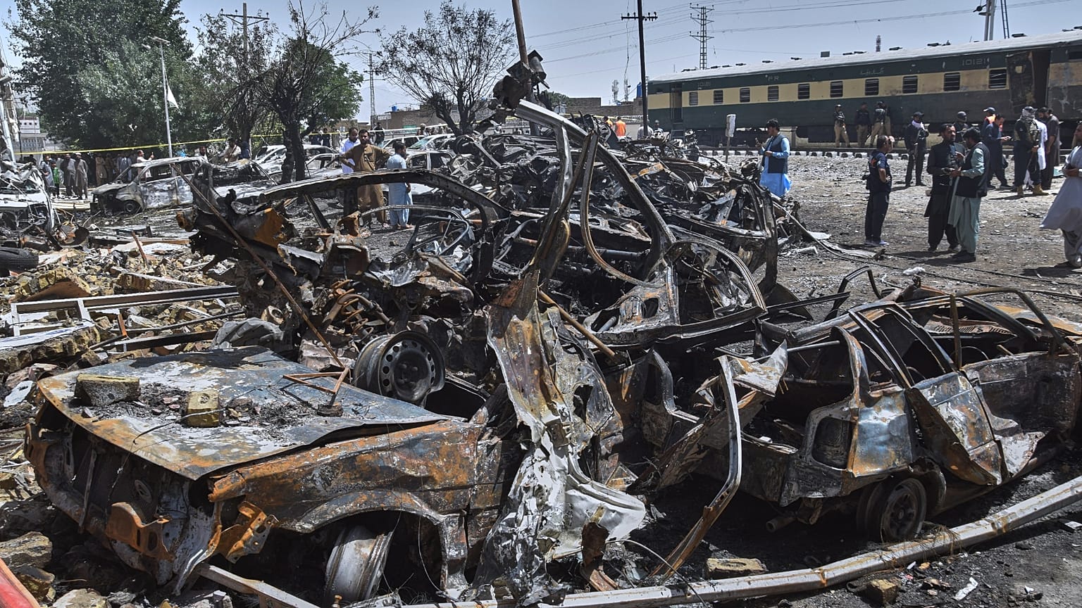 Police officers and local residents examine damages at the site of bomb explosion, in Quetta, Pakistan, Sunday, May 24, 2026.
