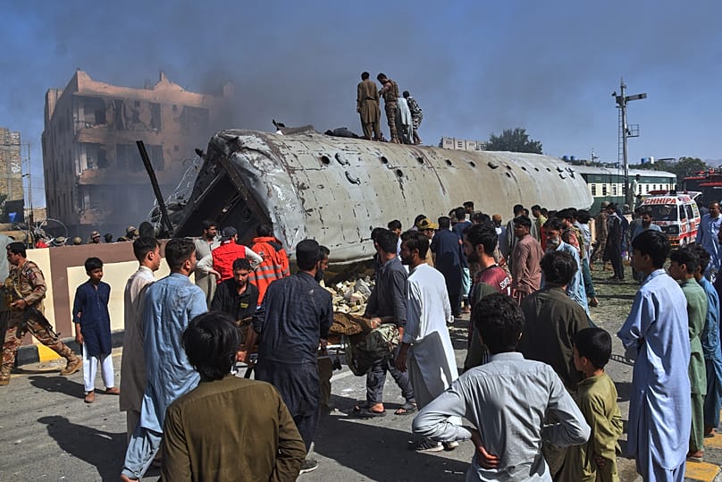 Volunteers transport an injured victim after recovering from an overturned train coach on a railway track at the site of bomb explosion, in Quetta, Pakistan, Sunday, May 24, 2