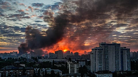 Following a heavy Russian air strike on Kyiv in Ukraine, smoke rises above the city at sunrise on Sunday, 24 May 2026. 