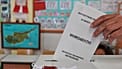 Un votante deposita su papeleta para las elecciones legislativas en un colegio electoral de Nicosia
