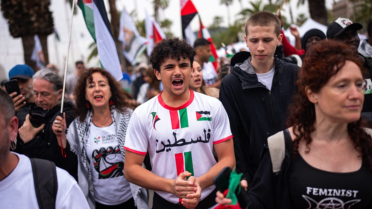 La gente corea consignas mientras se despide de activistas que zarpan para unirse a una flotilla civil con destino a Gaza en el puerto de Barcelona, el 12 de abril de 2026.