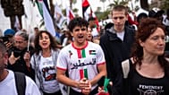 La gente corea consignas mientras se despide de activistas que zarpan para unirse a una flotilla civil con destino a Gaza en el puerto de Barcelona, el 12 de abril de 2026.