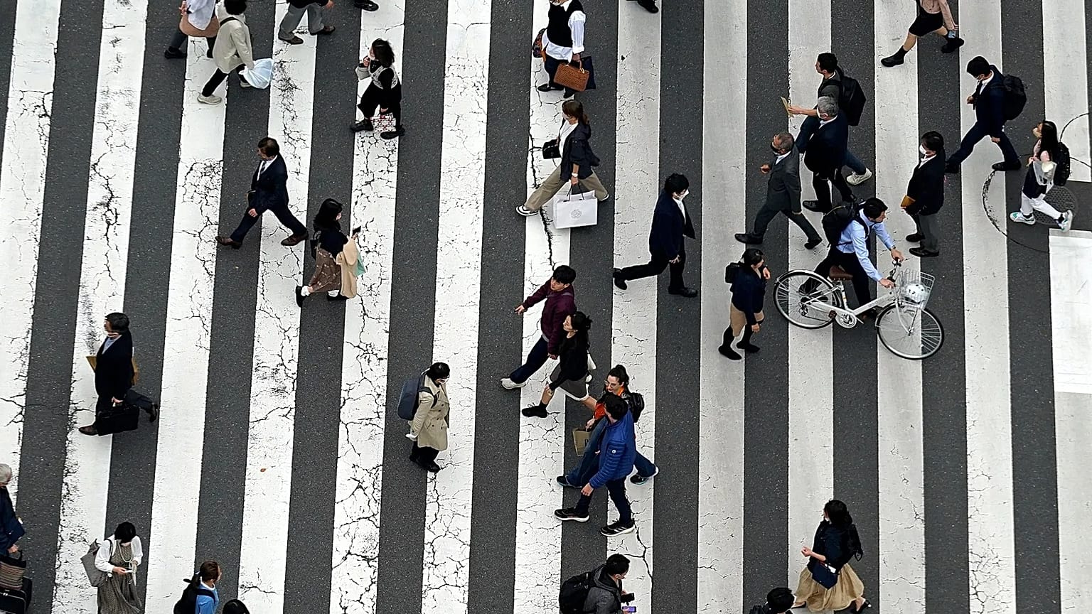 People walk along a pedestrian crossing at Ginza shopping street in Tokyo, 31 March, 2023