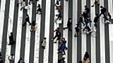 Ludzie przechodzą przez przejście dla pieszych na ulicy handlowej Ginza w Tokio, 31 marca 2023 r.