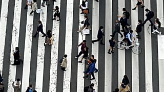 Des passants traversent un passage piéton dans le quartier commerçant de Ginza, à Tokyo, le 31 mars 2023