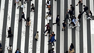 Pessoas atravessam uma passagem de peões na rua comercial de Ginza, em Tóquio, 31 de março de 2023