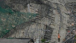 A rescuer stands on a collapsed building as search operations continue where multiple people are believed to be trapped in Angeles city, 25 May, 2026