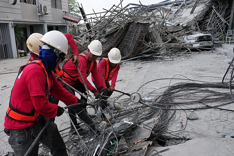 Workers cut cables during a search operation at a collapsed building where multiple people are believed to be trapped in Angeles city, 25 May, 2026