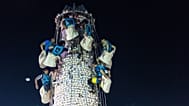 Participantes recolhem pãezinhos de uma torre coberta com pãezinhos de plástico durante o Festival do Pão em Cheung Chau, em Hong Kong, segunda-feira, 25 de maio de 2026