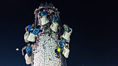 Des participants ramassent des brioches sur une tour couverte de brioches en plastique lors du festival des brioches sur l’île de Cheung Chau, à Hong Kong, le 25 mai 2026.