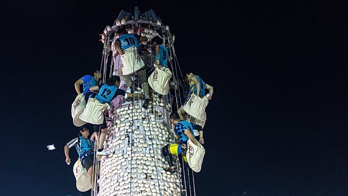 Escaladores compiten en torre de bollos del colorido festival de Hong Kong