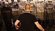Un manifestant antigouvernemental nargue la police antiémeute lors d’un rassemblement mené par des étudiants serbes en grève