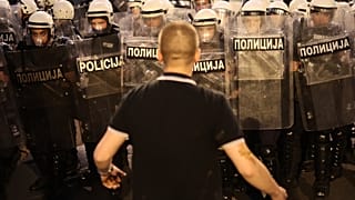 An anti-government protester taunts riot police during a rally led by Serbia's protesting university students