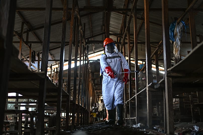 A sanitation worker from the Bunia city government sprays chlorine to disinfect the central market in Bunia, 23 May, 2026