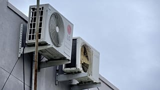 Air conditioning units attached to the side of a building.