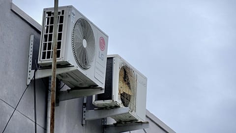 Air conditioning units attached to the side of a building.