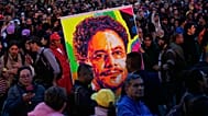 Simpatizantes del candidato presidencial Iván Cepeda, de la coalición gobernante Pacto Histórico, sostienen una pancarta con su imagen durante un mitin de campaña en Bogotá
