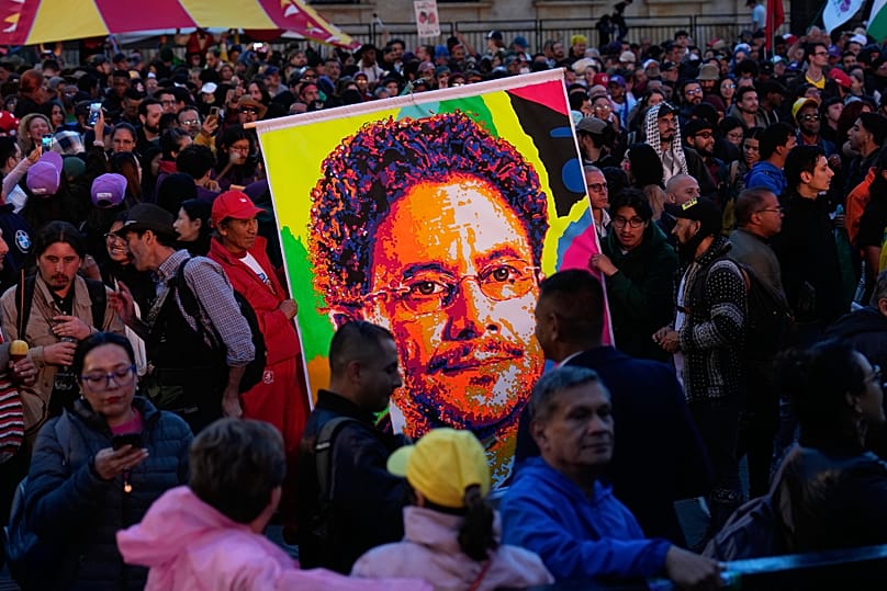 Varios simpatizantes de Cepeda sostienen una insignia de su rostro durante un mitín en Bogotá del viernes 22 de mayo de 2026