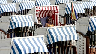 Urlauber im Strandkorb am Strand von Lübeck-Travemünde an der Ostsee (Symbolbild) 