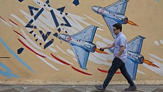 رهگذری در تهران در برابر دیوارنگاره ضداسرائیلی