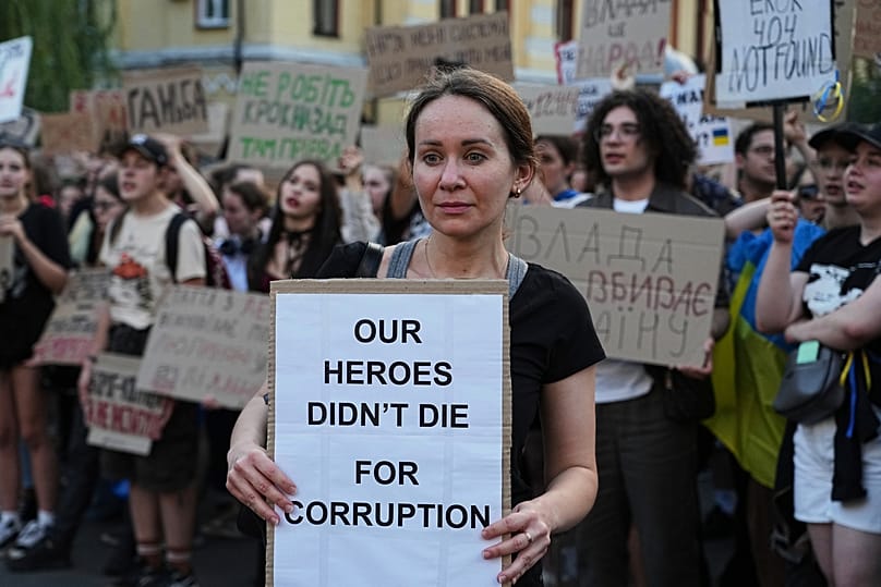 Una donna regge uno striscione durante una protesta contro una legge che prende di mira le istituzioni anticorruzione nel centro di Kyiv, in Ucraina, mercoledì 23 luglio 2025