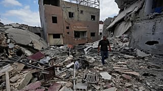 A man walks between destroyed buildings that were hit in Israeli airstrikes in Burj al-Shemali village near the southern port city of Tyre, Lebanon, Tuesday, May 26, 2026. (AP