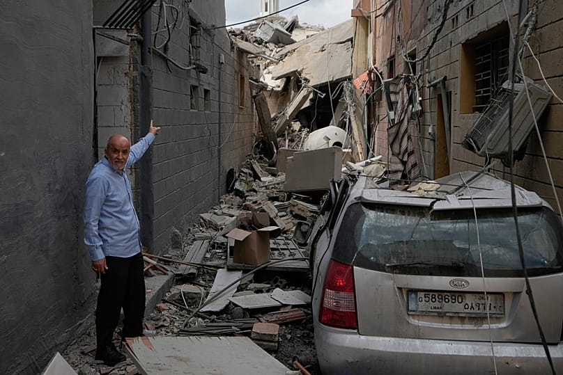 A man points into a destroyed building that was hit in an Israeli airstrike in Burj al-Shemali village near the southern port city of Tyre, Lebanon, Tuesday, May 26, 2026. (AP