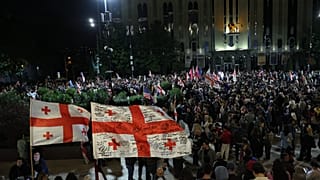 Des manifestants avec des drapeaux géorgiens participent à un rassemblement de l'opposition pour la fête de l'indépendance à Tbilissi, le 26 mai 2026. (AP/Z. Tsertsvadze)