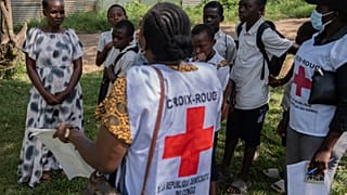 Vanny Birungi, voluntaria de la Cruz Roja, habla con vecinos durante una campaña de información puerta a puerta por el brote de ébola en Bunia, Congo, el 25 de mayo de 2026.