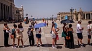 People queue to enter the Royal Palace during a hot and sunny day of summer in Madrid, Spain, Wednesday, July 19, 2023.