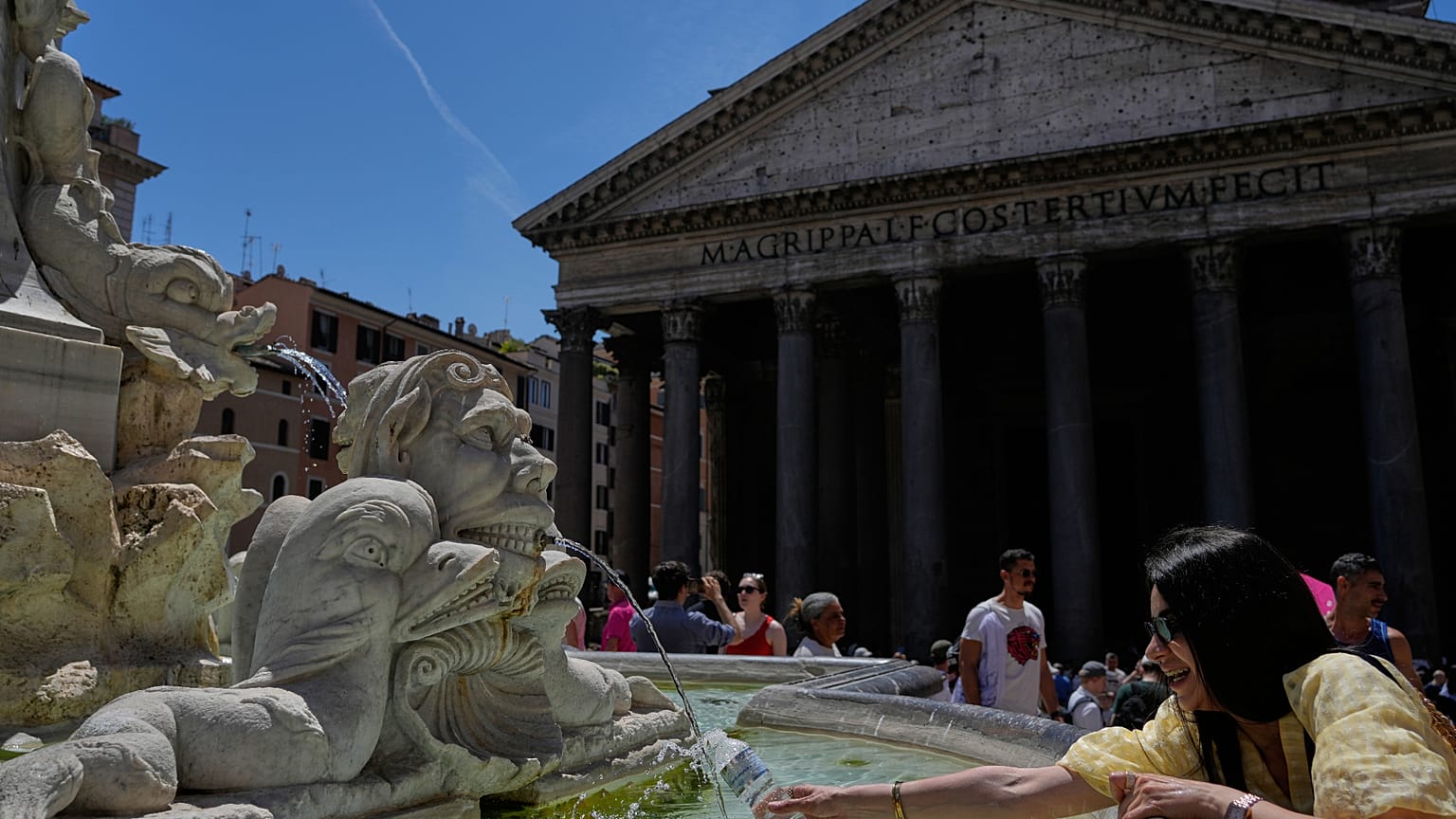 A woman fills a bottle with water at the Pantheon in downtown Rome as temperatures are expected to reach 32 degrees Celsius (89.6 Fahrenheit), Tuesday, May 26, 2026. (AP Photo