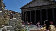 A woman fills a bottle with water at the Pantheon in downtown Rome as temperatures are expected to reach 32 degrees Celsius (89.6 Fahrenheit), Tuesday, May 26, 2026. (AP Photo