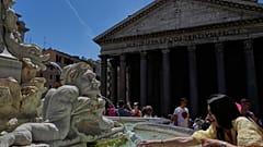 Eine Frau füllt am Dienstag, 26. Mai 2026, am Pantheon im Zentrum Roms eine Flasche mit Wasser. Die Temperaturen sollen auf 32 Grad Celsius steigen. (AP Photo