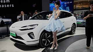 File - A model poses near the Sea Lion 06 DM-i model from BYD at the Shanghai auto show on Wednesday, 23 April 2025.