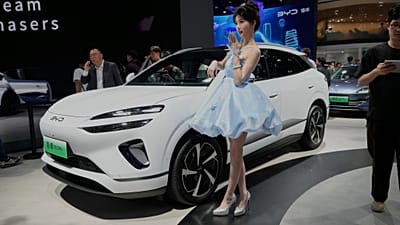 File - A model poses near the Sea Lion 06 DM-i model from BYD at the Shanghai auto show on Wednesday, 23 April 2025.