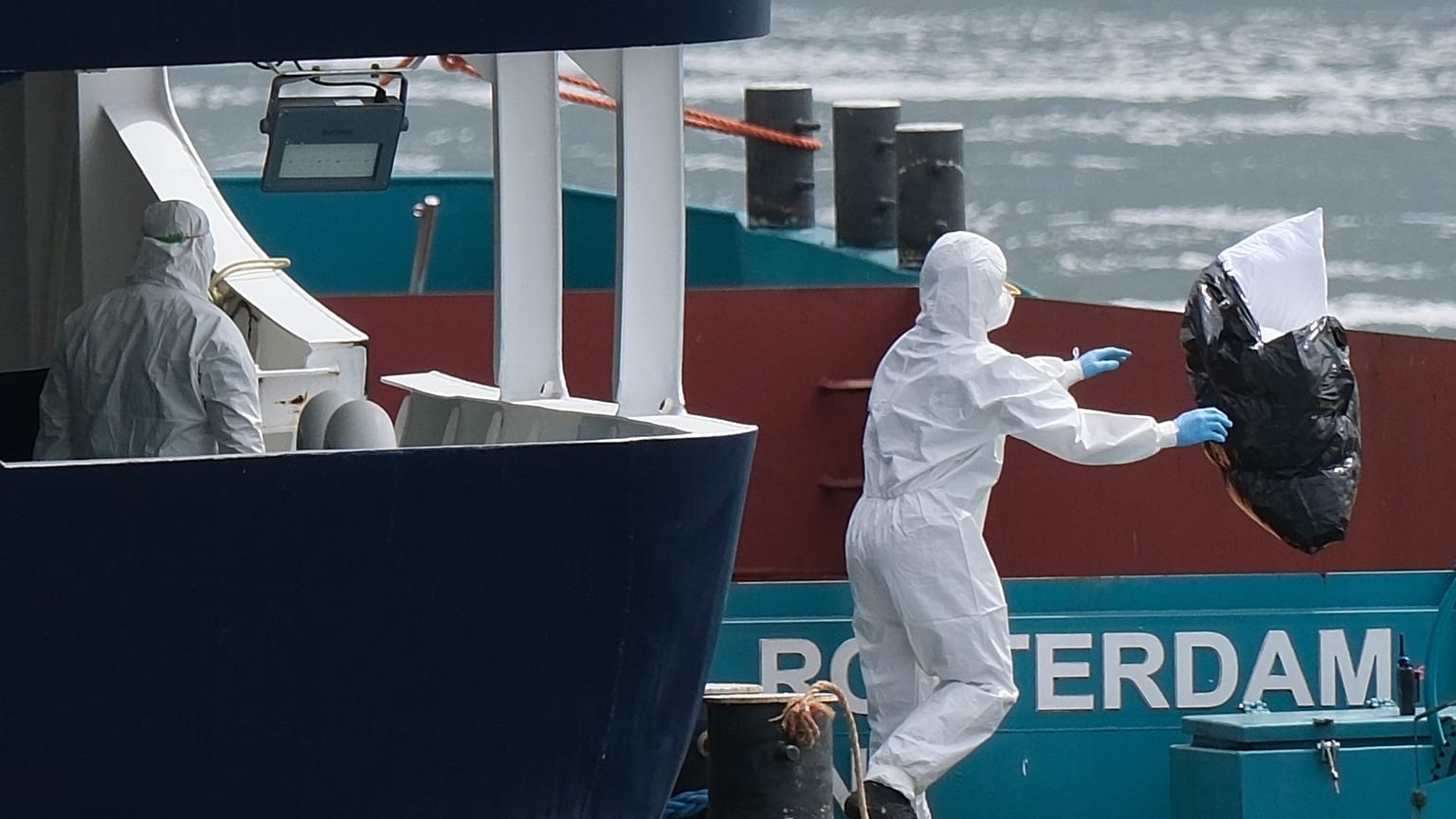 People in protective gear remove waste from the MV Hondius cruise ship after its arrival at the Port of Rotterdam, Netherlands, Monday, May 18, 2026.