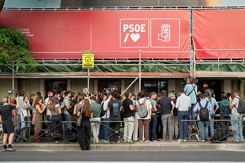 Journalists gather outside the headquarters of Spain's ruling Socialist Party as police search the building in Madrid, 27 May, 2026